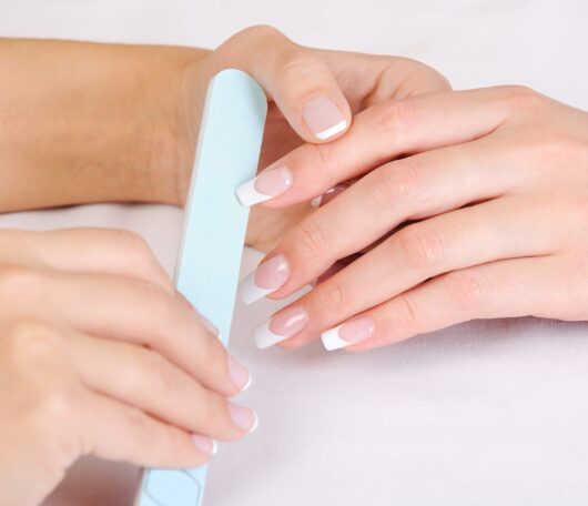 manicurist-doing-polishing-female-fingernails-with-french-manicure